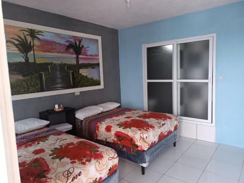 Habitación con 2 camas y ventana en CASA EMILY en San Pedro La Laguna
