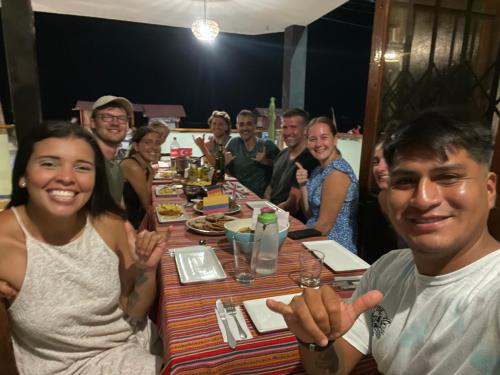 un grupo de personas sentadas alrededor de una mesa en Totora Surf Hostel, en Huanchaco