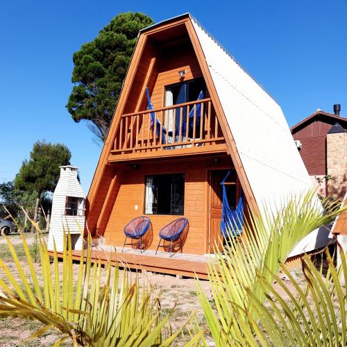 a house with two chairs and a balcony at Chalés Ilha da Mata Pousada in Florianópolis