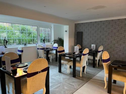 a dining room with tables and chairs and a window at G Boutique Hotel in Portsmouth
