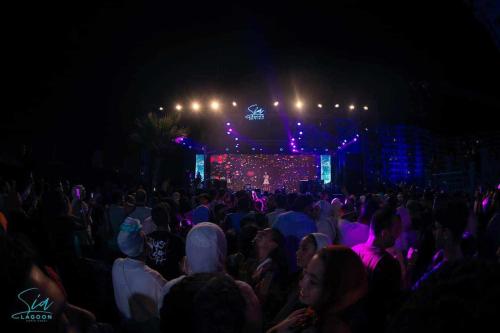 uma multidão de pessoas assistindo a um concerto à noite em Sia Lagoons, Porto Golf Marina, North Coast, El Alamein, Egypt em El Alamein