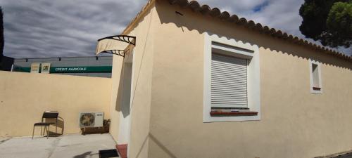 a window on the side of a building with a chair at Le Pavillon Les BUISSONNETS in Salon-de-Provence