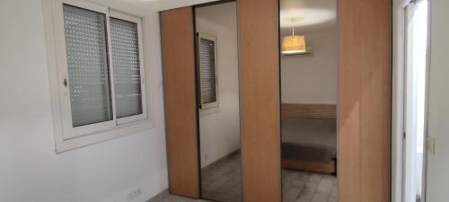 - un couloir avec un miroir et une porte menant à une chambre dans l'établissement Le Pavillon Les BUISSONNETS, à Salon-de-Provence