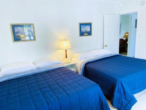 two beds in a room with blue sheets at Beach Tide Motel in Hollywood