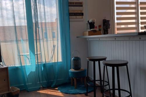 Zimmer mit zwei Barhockern und einem Fenster in der Unterkunft L'Escapade Appartement T1 douillet tout confort in Roanne
