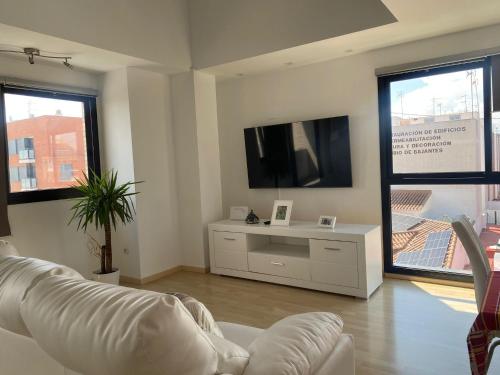 sala de estar con sofá blanco y TV de pantalla plana en Habitaciones confort, en Benetúser