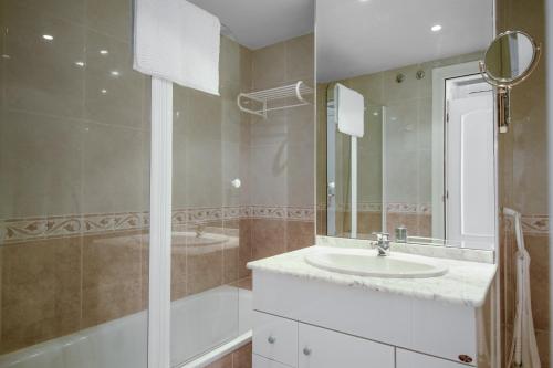 a bathroom with a sink and a tub and a mirror at Apartamento con espectaculares vistas al Golf en Marbella - Xallas 2 3 in Marbella