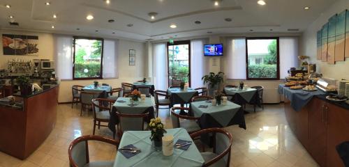a restaurant with tables and chairs in a room at Arcangelo Roof Hotel in Rimini