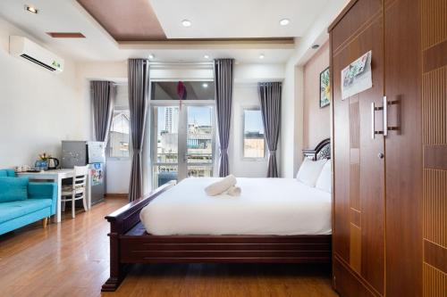 Un dormitorio con una gran cama blanca y un sofá azul. en Nina Home- De Tham Street, D1, en Ho Chi Minh
