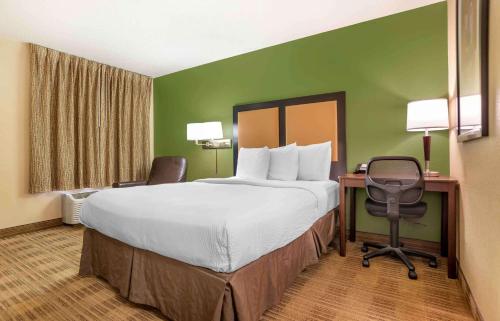 ein Hotelzimmer mit einem großen Bett und einem Schreibtisch in der Unterkunft Extended Stay America Select Suites - Jackson - North in Jackson