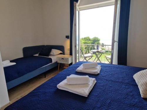 een slaapkamer met 2 bedden met handdoeken en een balkon bij Apartment Ana - Gradac in Gradac
