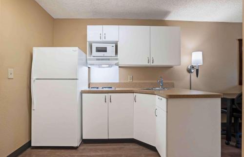 cocina con armarios blancos y nevera blanca en Extended Stay America Suites - San Diego - Hotel Circle en San Diego