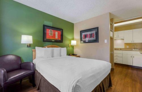 a bedroom with a large bed and a chair at Extended Stay America Suites - Phoenix - Scottsdale - Old Town in Scottsdale