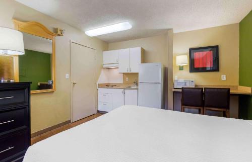 a room with a white bed and a kitchen at Extended Stay America Suites - Phoenix - Scottsdale - Old Town in Scottsdale