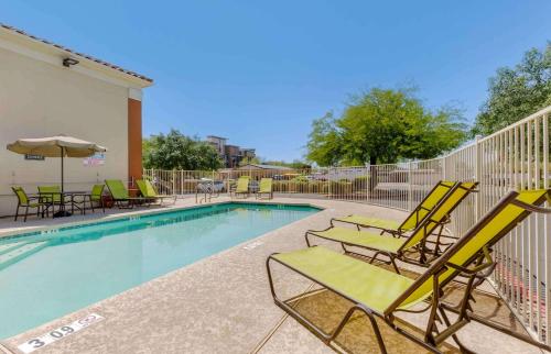 a swimming pool with lounge chairs and an umbrella at Extended Stay America Suites - Phoenix - Scottsdale - Old Town in Scottsdale