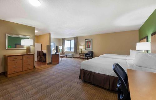 Großes Hotelzimmer mit einem Bett und einem Schreibtisch. in der Unterkunft Extended Stay America Suites - Madison - Old Sauk Rd in Madison