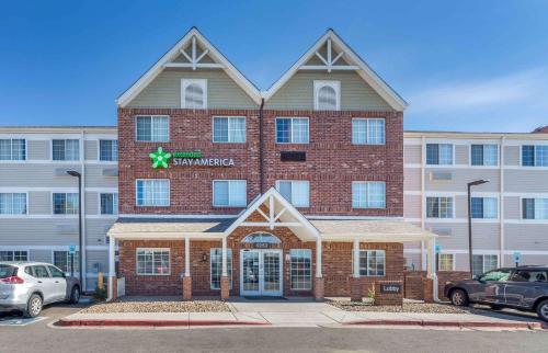 a large brick building in front of a parking lot at Extended Stay America Select Suites - Denver - Tech Center South - Greenwood Village in Centennial