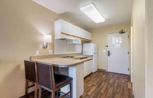 a small kitchen with a counter and two chairs at Extended Stay America Suites - Minneapolis - Eden Prairie - Technology Drive in Eden Prairie