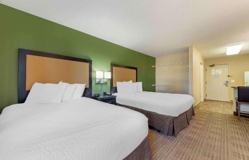a hotel room with two beds and a green wall at Extended Stay America Suites - Minneapolis - Eden Prairie - Technology Drive in Eden Prairie