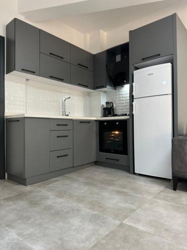 a kitchen with a white refrigerator and black cabinets at Suite64 Apartments in Antalya