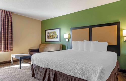 a hotel room with a large bed and a chair at Extended Stay America Suites - Minneapolis - Eden Prairie - Technology Drive in Eden Prairie