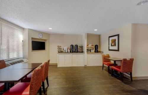 a dining room with a table and chairs and a television at Extended Stay America Select Suites - Dallas - Las Colinas - Meadow Creek Dr in Irving