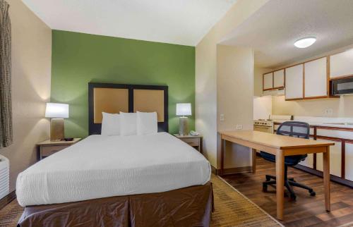 a bedroom with a bed and a desk and a kitchen at Extended Stay America Select Suites - Dallas - Las Colinas - Meadow Creek Dr in Irving
