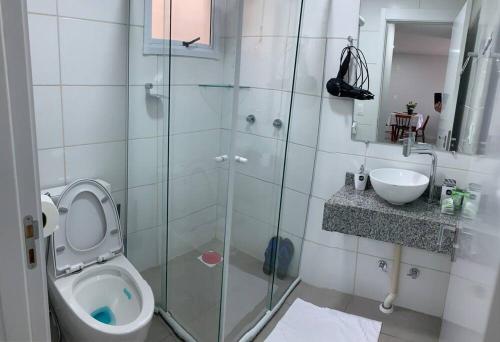 a bathroom with a shower and a toilet and a sink at Ap aconchego Acqua in Pelotas