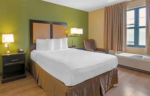 a hotel room with a large bed and a chair at Extended Stay America Suites - Stockton - March Lane in Stockton