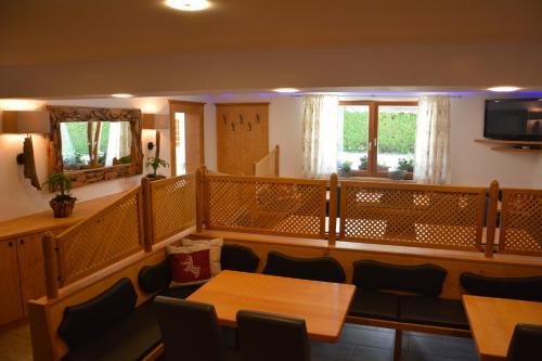 a dining room with tables and chairs and a television at Pension Milan in Zell am See