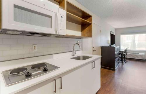 a kitchen with a sink and a microwave at Extended Stay America Suites - San Jose - Milpitas - McCarthy Ranch in Milpitas