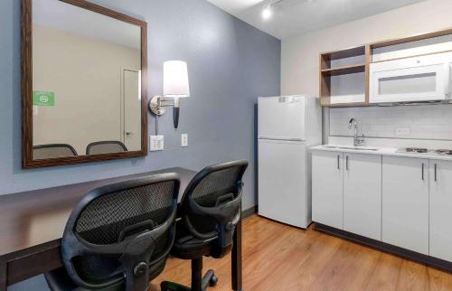 uma cozinha com 2 cadeiras e um frigorífico branco em Extended Stay America Suites - San Francisco - San Mateo - SFO em San Mateo