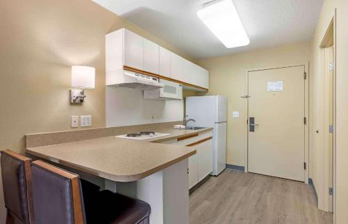 a small kitchen with a counter and a refrigerator at Extended Stay America Select Suites - St Louis - Airport - Central in Bridgeton