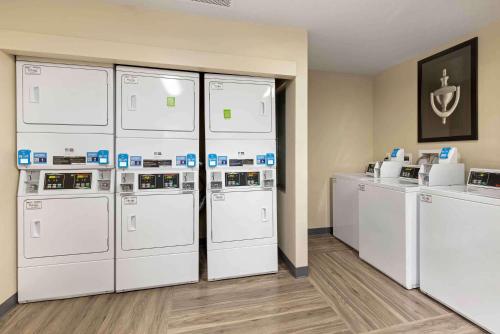 a row of white washers and dryers in a room at Extended Stay America Select Suites - St Louis - Airport - Central in Bridgeton