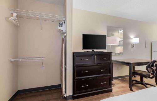a room with a desk with a tv and a table with a computer at Extended Stay America Suites - Dallas - Coit Road in Dallas