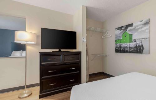 a bedroom with a bed and a television on a dresser at Extended Stay America Suites - Dallas - Coit Road in Dallas