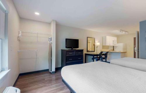 a bedroom with a bed and a tv and a desk at Extended Stay America Suites - Dallas - Coit Road in Dallas
