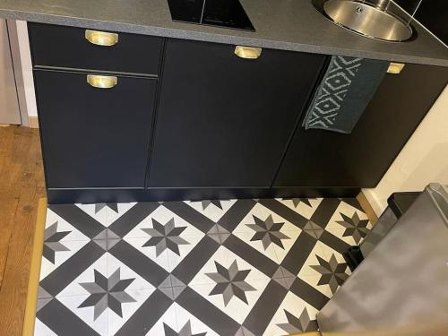 Il comprend une cuisine avec un comptoir et du carrelage. dans l'établissement Le Black and White studio centre-ville historique, à Bourges