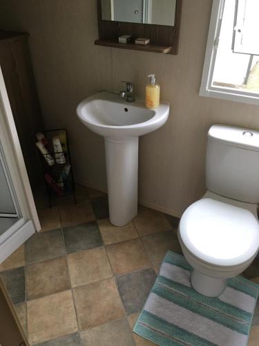 a bathroom with a white toilet and a sink at Devon Cliffs Exmouth Sandy Bay 3 bedrooms in Exmouth
