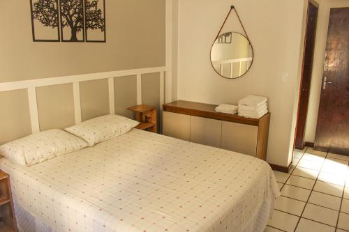 a small bedroom with a bed and a mirror at Apartamento amplo e completo no centro Balneário Camboriú in Balneário Camboriú