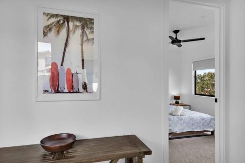 a room with a table and a bed and palm trees at Kira Lani - Pet friendly Tura in Tura Beach