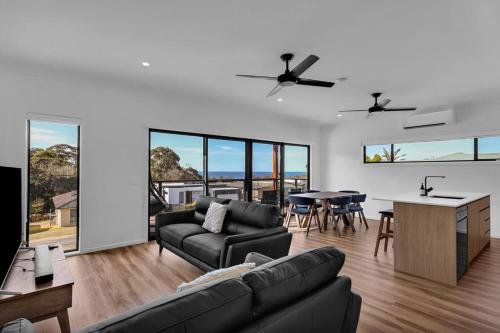 a living room with a couch and a table at Kira Lani - Pet friendly Tura in Tura Beach