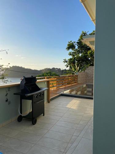 a grill on a balcony with a view of the water at Le Lointain in Mtsamboro