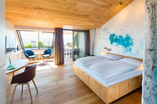 a bedroom with a bed and a table and chairs at Hotel Seehof in Immenstaad am Bodensee