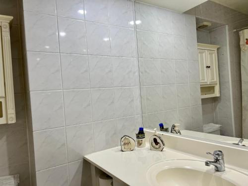 a white bathroom with a sink and a mirror at VISTAMAR CORACEROS VIÑA DEL MAR in Viña del Mar