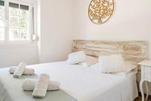 a white bedroom with a white bed with towels on it at Cozy Haven Retreat in Lisbon