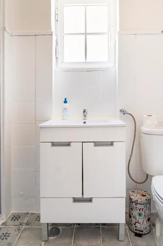 a white bathroom with a sink and a toilet at Cozy House in Lisbon with Terrace, Tejo Peek and Easy Parking in Lisbon