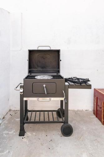 a grill sitting on a cart in a room at Cozy House in Lisbon with Terrace, Tejo Peek and Easy Parking in Lisbon