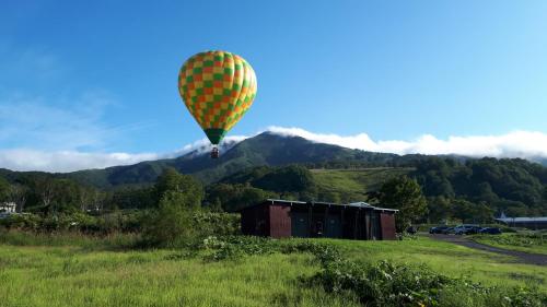 a hot air balloon is flying over a field at Bistare Kana in Niseko