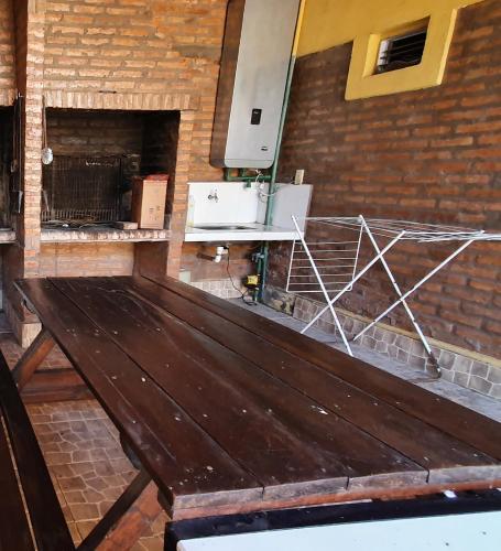 a wooden bench in front of a brick wall at EL CHALET in Termas de Río Hondo